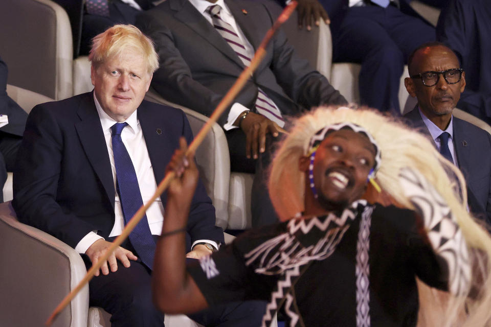 British Prime Minister Boris Johnson, left, and Rwandan President Paul Kagame, right, look at traditional dancers performing during the opening ceremony of the Commonwealth Heads of Government Meeting (CHOGM) on Friday, June 24, 2022 in Kigali, Rwanda. Leaders of Commonwealth nations are meeting in Rwanda Friday in a summit that promises to tackle climate change, tropical diseases and other challenges deepened by the COVID-19 pandemic. (Dan Kitwood/Pool Photo via AP)