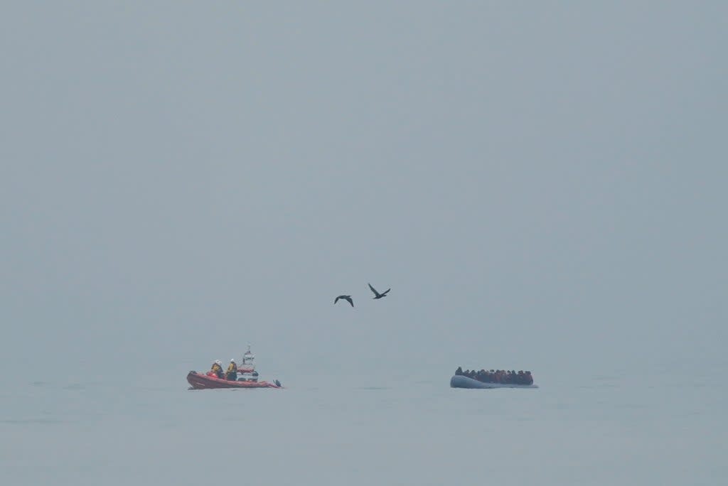 A lifeboat escorts a dinghy carrying people thought to be migrants, off the coast of Dungeness in Kent on Saturday (Gareth Fuller/PA) (PA Wire)