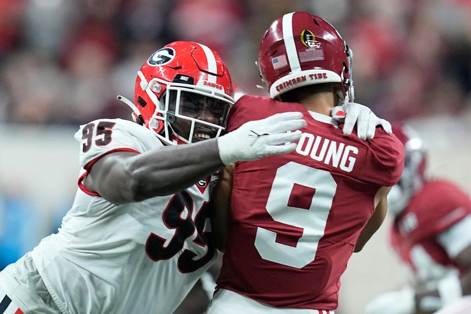 Georgia's Devonte Wyatt hits Alabama's Bryce Young as he throws during the first half of the College Football Playoff championship football game Monday, Jan. 10, 2022, in Indianapolis. (AP Photo/Darron Cummings)