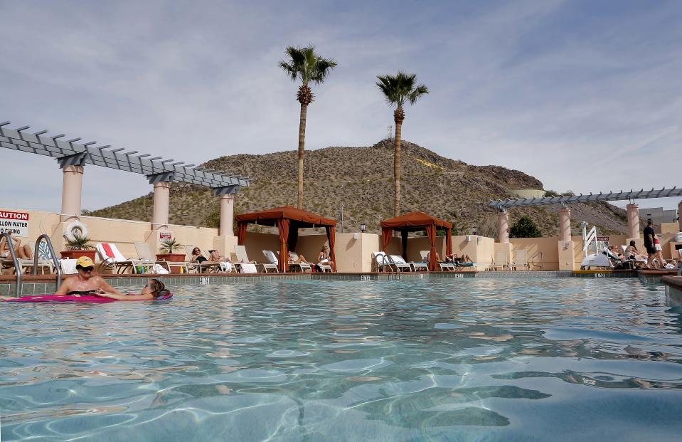 Guests lounge in the pool at the Mission Palms, Friday, Feb. 14, 2014 in Tempe, Ariz. With large parts of the country in the grips of frigid cold and snow and ice storms, the Southwest is enjoying a heat wave that is setting record highs and sending people to pools, golf courses and beaches in large numbers. Phoenix and Los Angeles are experiencing unusually warm 80-degree weather that has residents and visitors rejoicing as they look at the mess on the East Coast.(AP Photo/Matt York)