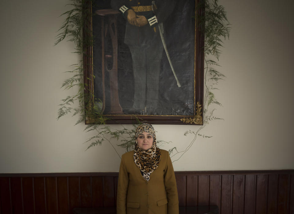 In this Wednesday, March 26, 2014 photo Afghan lawmaker Fatema Aziz from Kunduz poses under an oil painting in the parliament in Kabul, Afghanistan. When the Taliban ruled, women rarely left their home. When they did venture beyond their four walls, they wafted through crowded markets covered from head to toe in the all-encompassing burqa. While most women in conservative Afghanistan may still wear the burqa, today’s Afghan woman has choices she never had before, like running for parliament. (AP Photo/Anja Niedringhaus)