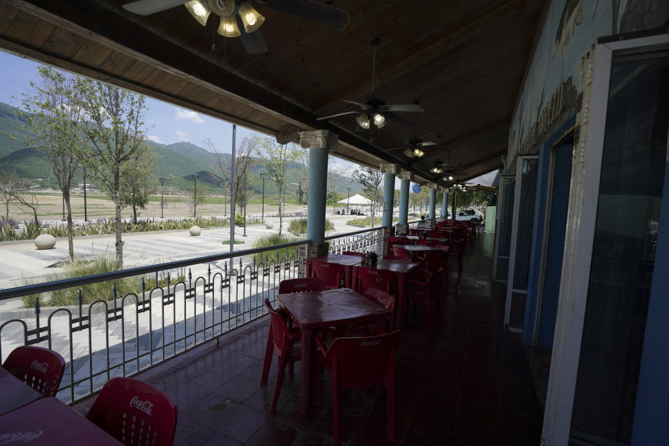 Empty tables in a restaurant are seen along the beach front in The Boca reservoir that supplies water to the northern city of Monterrey, in Santiago, Mexico, Saturday, July 9, 2022. The reservoir is almost dry as the northern part of Mexico is affected by an intense drought. (AP Photo/Fernando Llano)