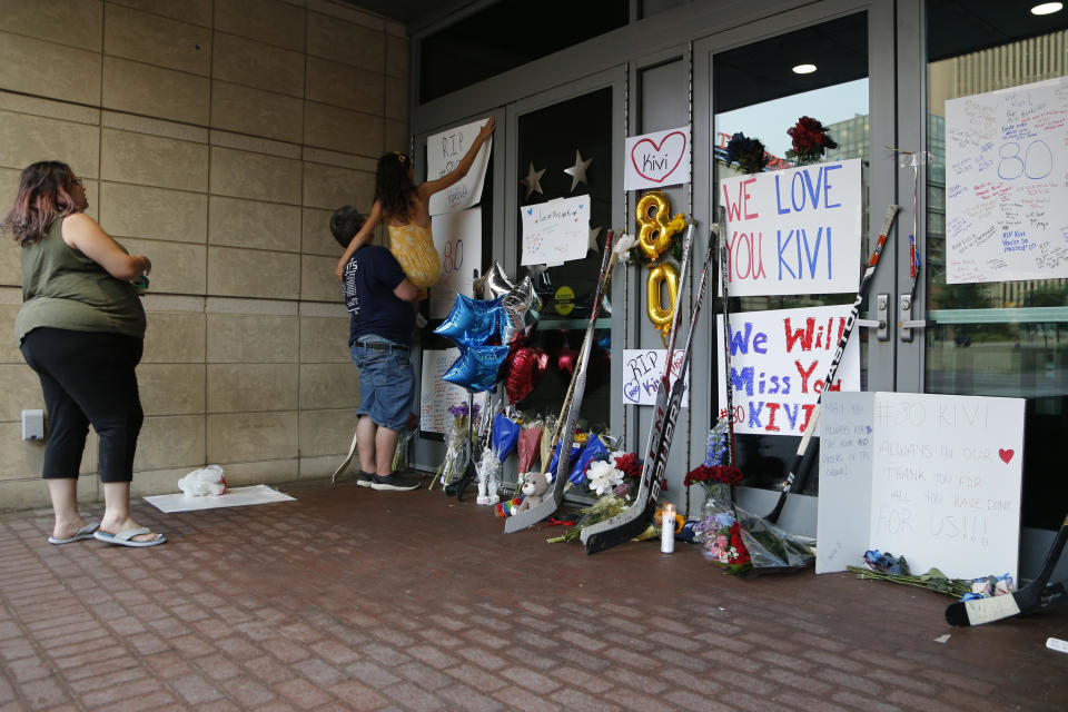 Tasha Gantner, left, with her husband Sam, center, and daughter Nancy visit a makeshift memorial in front of Nationwide Arena Monday, July 5, 2021, in Columbus, Ohio, to remember Columbus Blue Jackets goaltender Matiss Kivlenieks who died of chest trauma from an errant fireworks mortar blast in what authorities described Monday as a tragic accident on the Fourth of July. (AP Photo/Jay LaPrete)