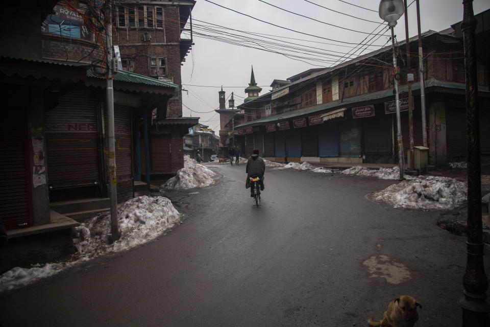 A Kashmiri man rides a bicycle through a closed market in Srinagar, Indian controlled Kashmir, Tuesday, Feb. 9, 2021. Businesses and shops have closed in many parts of Indian-controlled Kashmir to mark the eighth anniversary of the secret execution of a Kashmiri man in New Delhi. Hundreds of armed police and paramilitary soldiers in riot gear patrolled as most residents stayed indoors in the disputed region’s main city of Srinagar. (AP Photo/Mukhtar Khan)