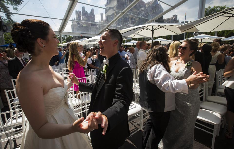 Murphy and St. Germain dance after the ceremony for "The Celebration of Love", a grand wedding where over 100 LGBT couples got married, at Casa Loma in Toronto