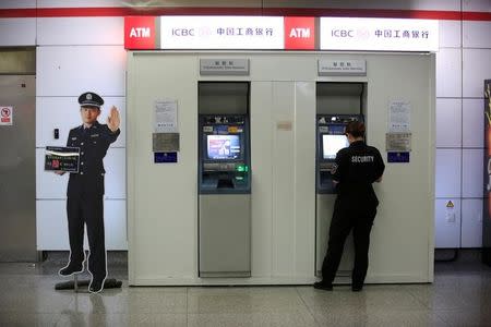 A security guard checks an ICBC ATM at a subway station in Hangzhou, Zhejiang province, China, August 3, 2016. REUTERS/Aly Song