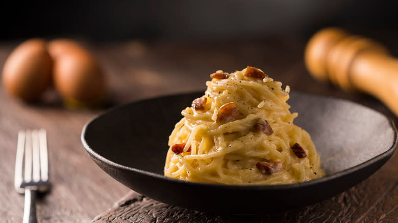 pasta carbonara in black bowl