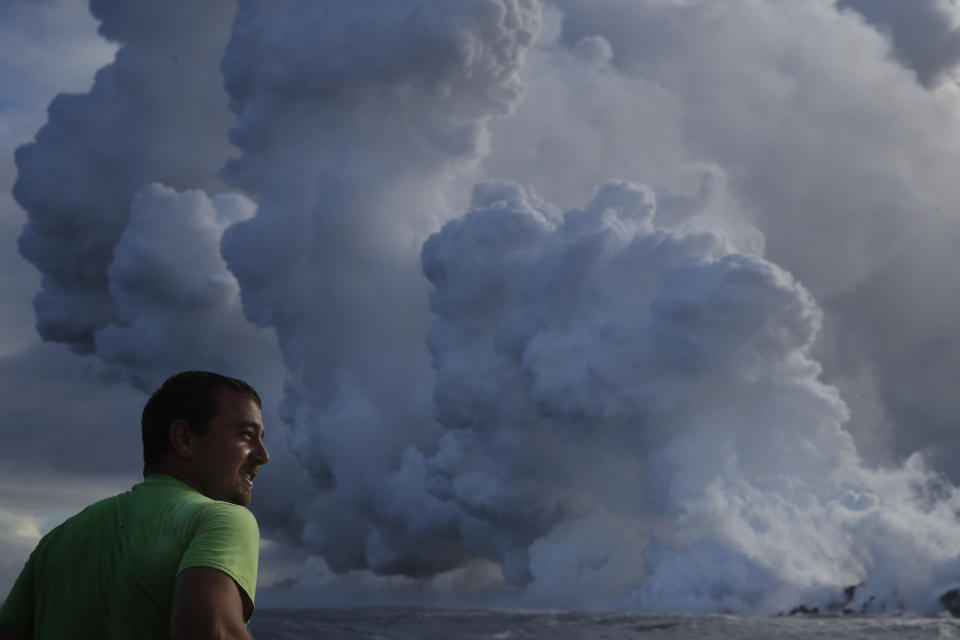 <p>Joe Kekedi watches as lava enters the ocean, generating plumes of steam near Pahoa, Hawaii, May 20, 2018. Kilauea volcano that is oozing, spewing and exploding on Hawaii’s Big Island has gotten more hazardous in recent days, with rivers of molten rock pouring into the ocean Sunday and flying lava causing the first major injury. (Photo: Jae C. Hong/AP) </p>