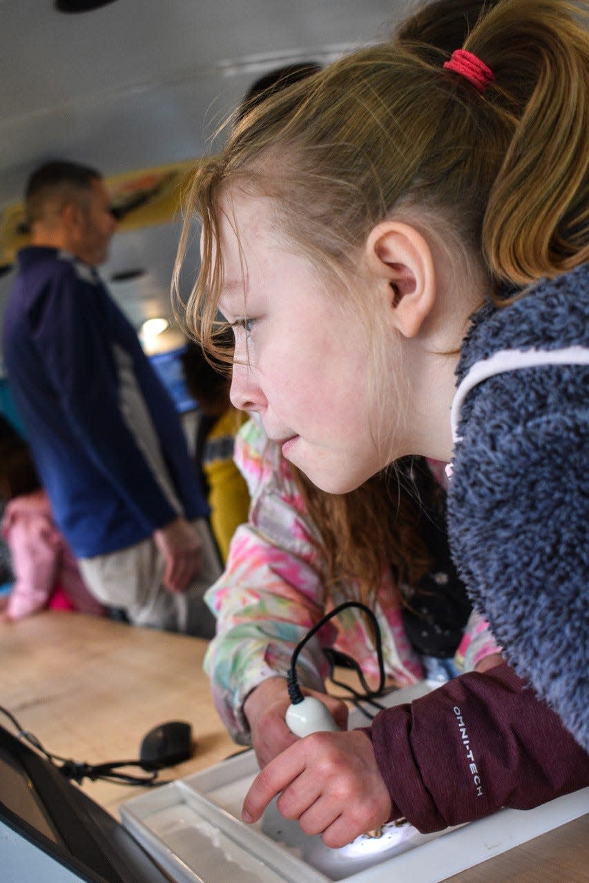 Phenix McCreery studies soil under a microcope on the Vanguard-Sentinel AIM Mobile Career Technology Lab that was brought to Atkinson Elementary School.