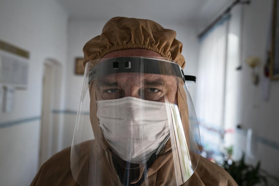 In this photo taken on Friday, May 1, 2020, doctor Ivan Venzhynovych, wearing special suit to protect against coronavirus, poses for a photo after morning examination patients with coronavirus at a hospital in Pochaiv, Ukraine. Ukraine's troubled health care system has been overwhelmed by COVID-19, even though it has reported a relatively low number of cases. (AP Photo/Evgeniy Maloletka)