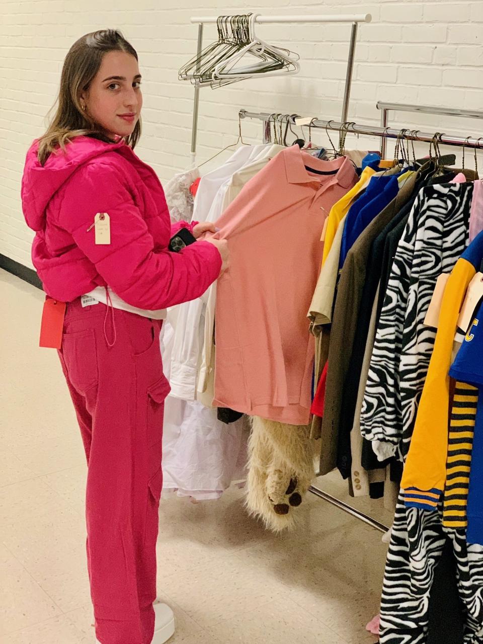 Zoe Schuldenfrei, who plays Regina George in Edgemont High School's production of "Mean Girls," takes a look at costumes during costume fittings. "On Wednesdays, we wear pink!"