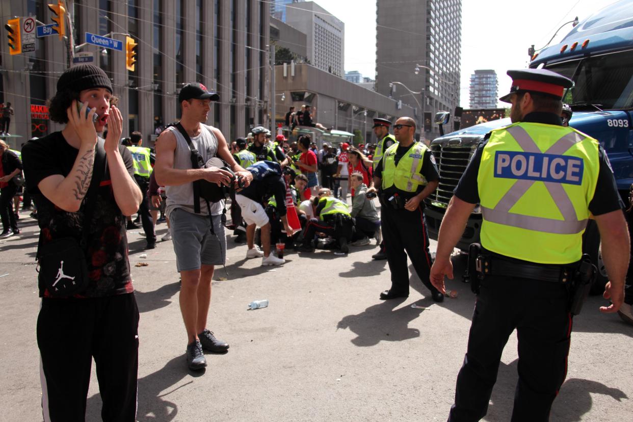 TORONTO, ON - JUNE 17: Police officers attend to an injured person after a shooting occurred during the Toronto Raptors Championship Victory Parade on June 17, 2019 in Toronto, Ontario. According to Toronto Police, Four people were reportedly injured in a shooting during the victory parade at Nathan Philip's square. None of the injuries were life threatening, three people were arrested and two firearms recovered.  (Photo by Yu Ruidong/China News Service/VCG via Getty Images)