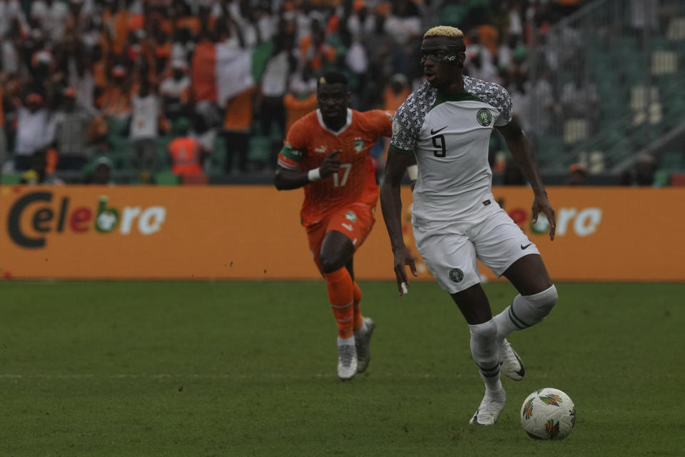 Victor Osimhen de Nigeria gambetea con el balón frente a Serge Aurier de Costa de Marfil en el encuentro del Grupo A de la Copa Africana de Naciones el jueves 18 de enero del 2024. (AP Foto/Sunday Alamba)