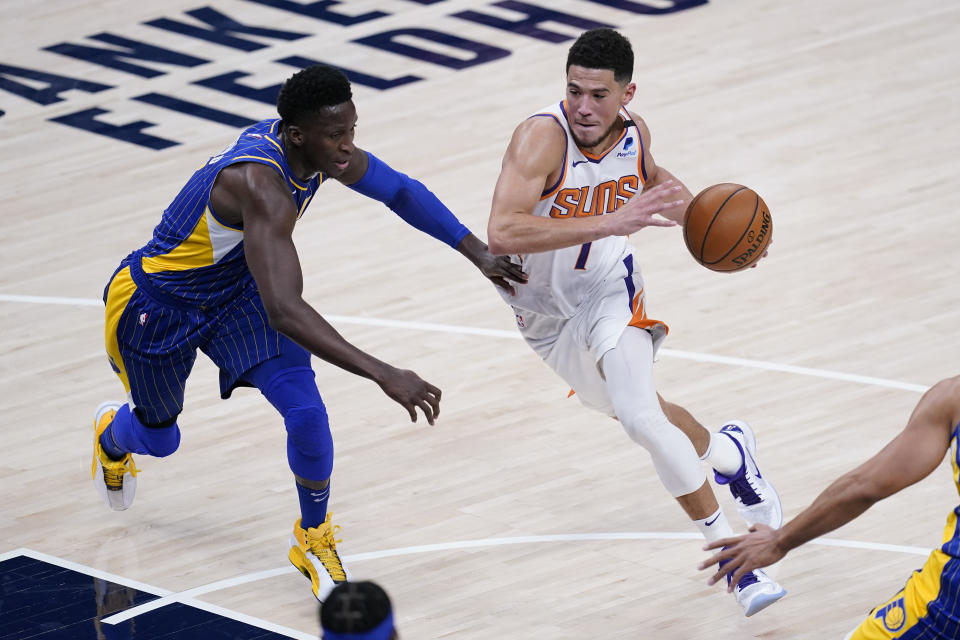 Phoenix Suns' Devin Booker (1) heads to the basket against Indiana Pacers' Victor Oladipo (4) during the first half of an NBA basketball game, Saturday, Jan. 9, 2021, in Indianapolis. (AP Photo/Darron Cummings)