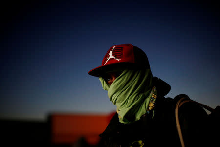 A migrant from Honduras, part of a caravan of thousands traveling from Central America to the United States, prepares to get on a bus bound for Mexicali at a makeshift camp in Navojoa, Mexico November 17, 2018. REUTERS/Kim Kyung-Hoon