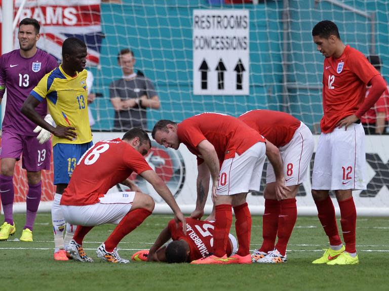 A picture taken on June 4, 2014 shows England players as they gather next to midfielder Alex Oxlade-Chamberlain injured during the friendly match between England and Ecuador at Miami Sun Life Stadium in Miami Gardens, Florida