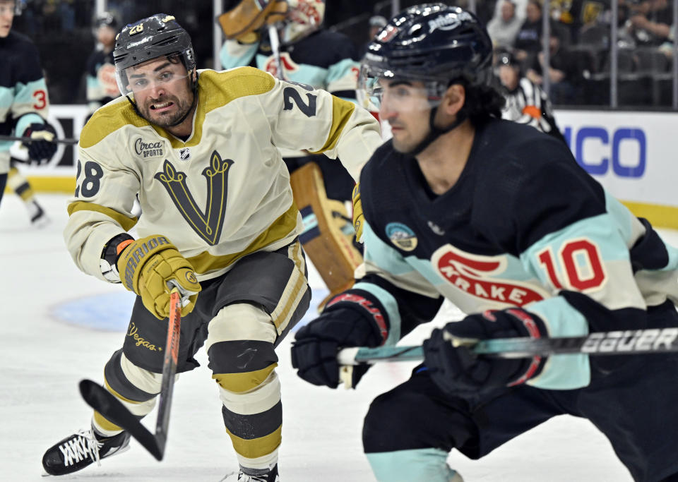 Vegas Golden Knights left wing William Carrier (28) chases the puck against Seattle Kraken center Matty Beniers (10) during the second period of an NHL hockey game Thursday, March 21, 2024, in Las Vegas. (AP Photo/David Becker)