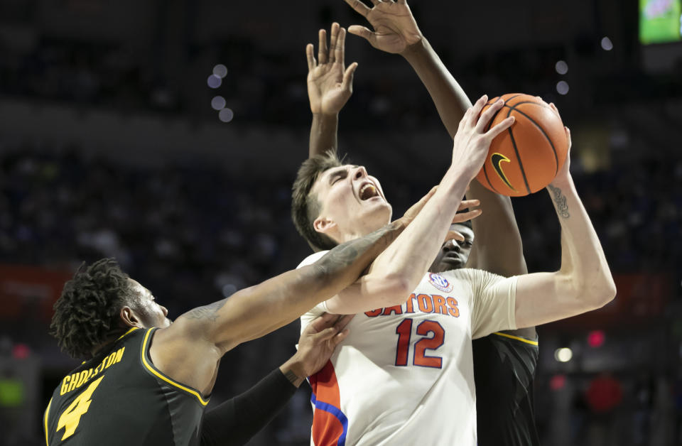 Florida forward Colin Castleton (12) gets fouled by Missouri guard DeAndre Gholston (4) under pressure from Missouri forward Mohamed Diarra, right, during the second half of an NCAA college basketball game Saturday, Jan. 14, 2023, in Gainesville, Fla. Florida won 73-64.(AP Photo/Alan Youngblood)