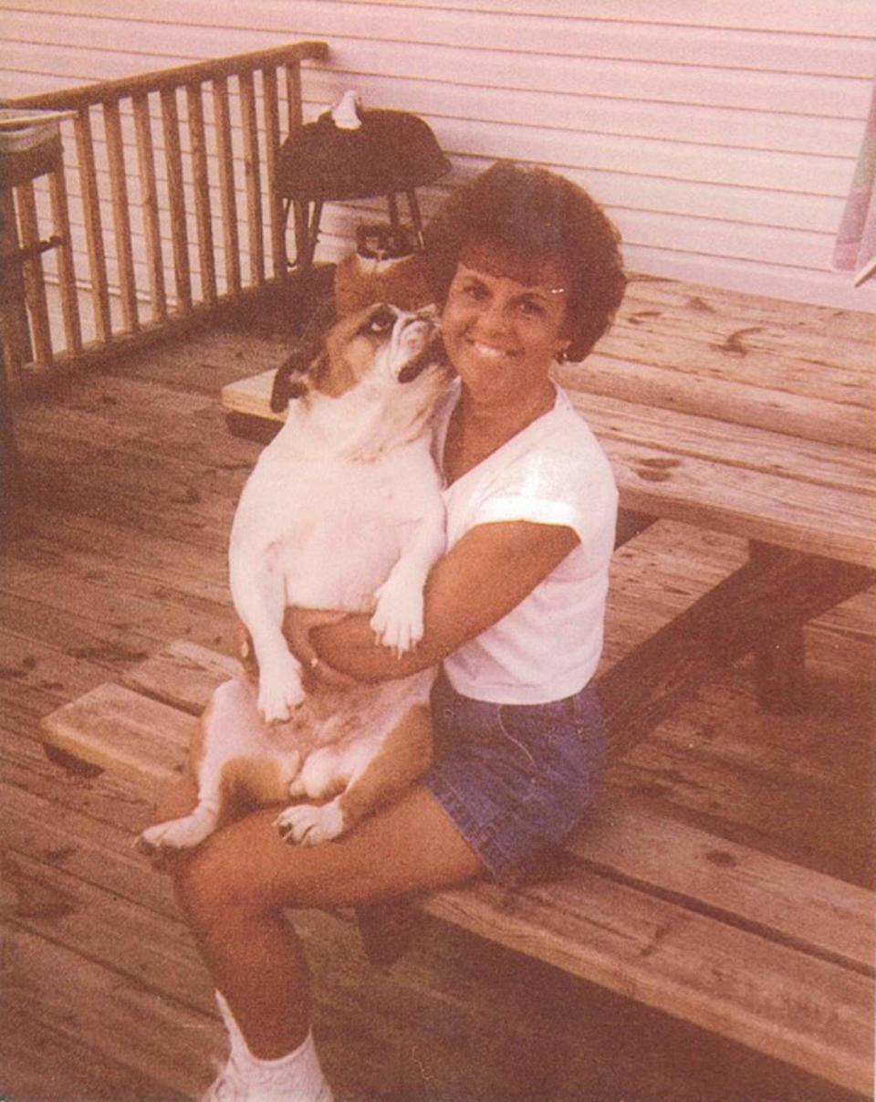 Doris Korell sits on a porch outside hugging a dog and smiling at the camera (Manatee County Sheriff’s Office)