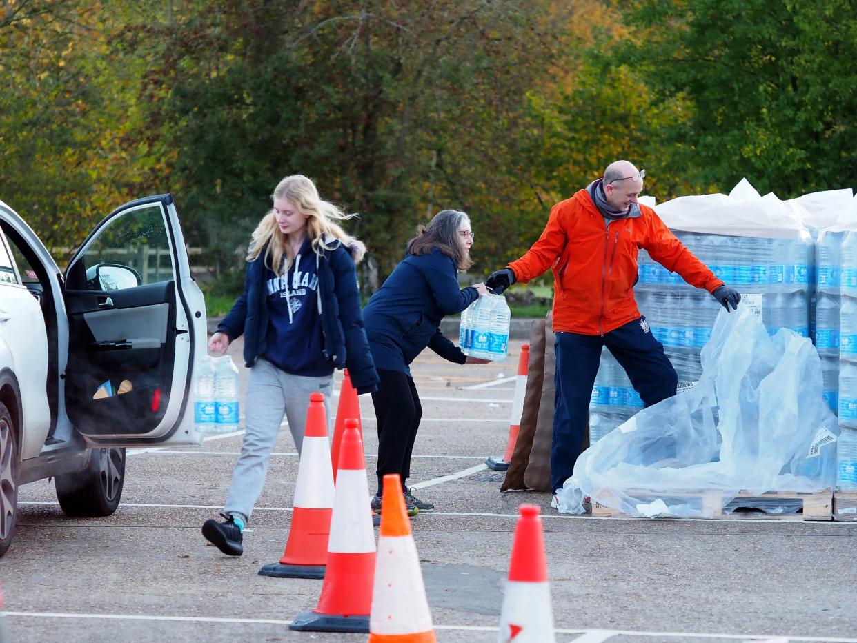 Local residents collect bottles of water in Godalming, Surrey, as almost 12,000 people were without running water in after Storm Ciaran (PA)