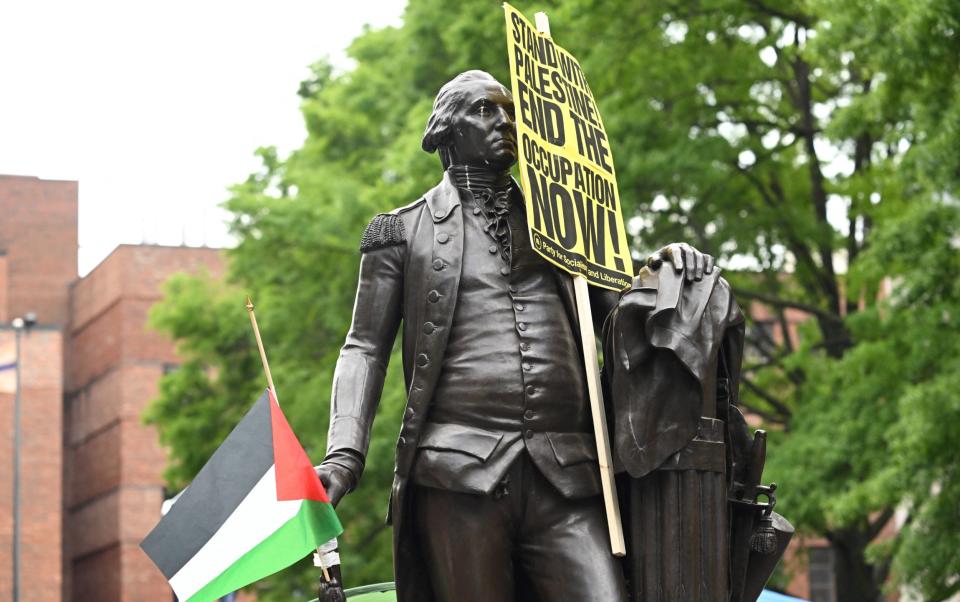 A placard hangs from a statue of George Washington at George Washington University, less than a mile from the White House