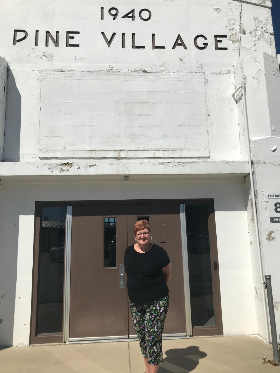 Gail Anderson poses in front of Pine Village gym. She and Alan are married. She's class of 1971, he's 1972. Both went to Purdue. She taught there 1983-98, and was principal 1999-2018.