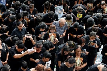 Mourners bow as they gather outside of the Grand Palace to sing for a recording of the royal anthem in honour of Thailand's late King Bhumibol Adulyadej, in Bangkok, Thailand, October 22, 2016. REUTERS/Jorge Silva