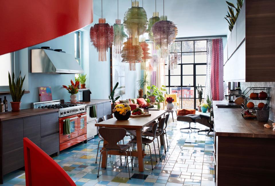 In the open kitchen and dining area, the table and cabinetry are by Ikea and the range is by Bertazzoni; the rear window wall looks out onto a courtyard created in collaboration with liz Campbell Kelly of Hudson Garden Studio.