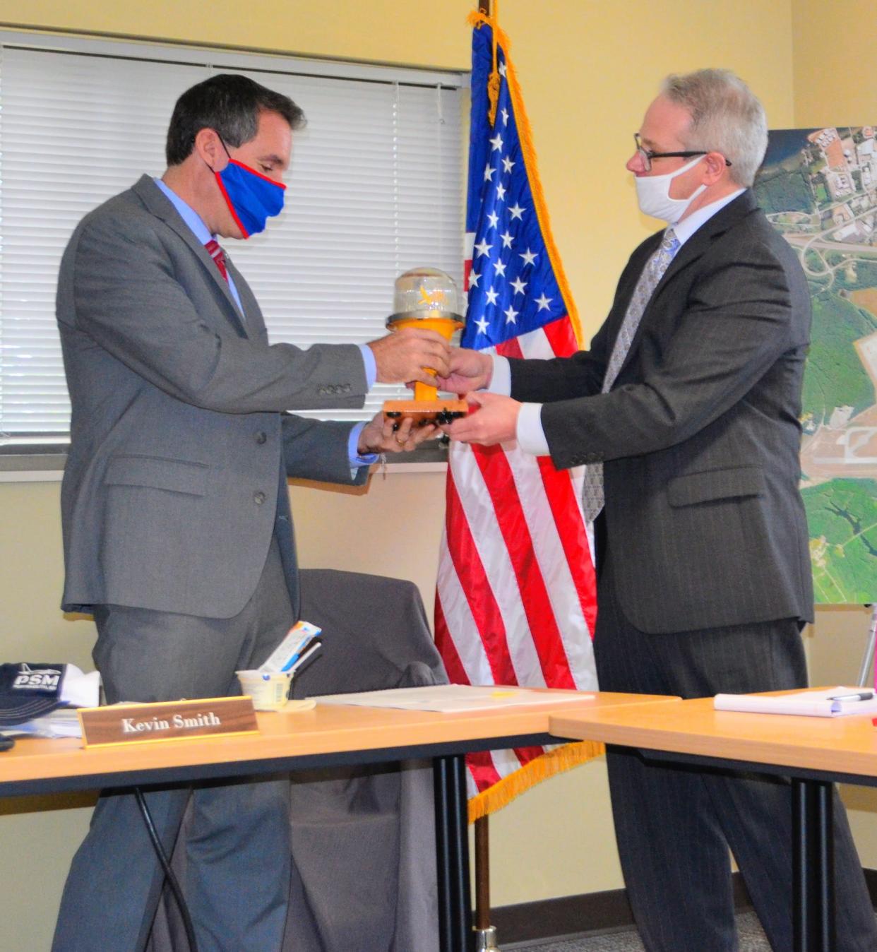 Pease Development Authority Executive Director Paul Brean, right, presents a parting gift to Kevin Smith, left, who resigned as chairman of the PDA board of directors in order to run for the U.S. Senate at the PDA meeting on Thursday, Jan. 20.