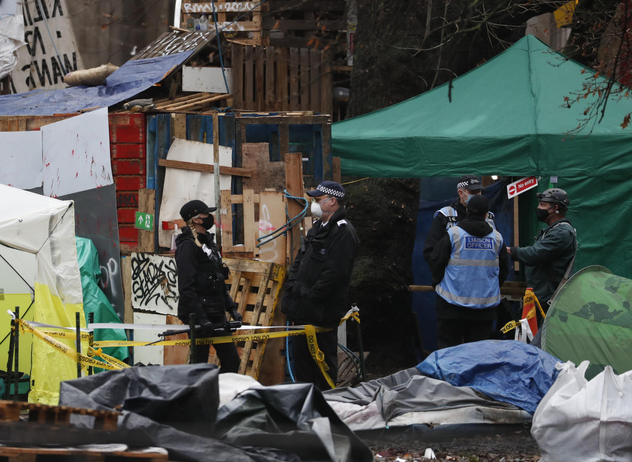 Police officers work to clear an HS2 protest camp outside Euston station in London, Thursday, Jan. 28, 2021. Some protesters against a high-speed rail link between London and northern England were evicted from a park in the capital city early Wednesday after they dug tunnels and set up a makeshift camp. (AP Photo/Alastair Grant)