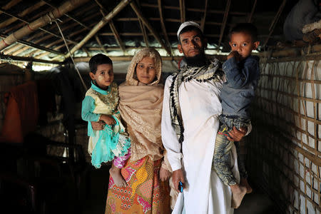 Kalim Ullah, his wife Taiyeba Begum and their children who take shelter in their relatives' tent to avoid forced repatriation, pose for a picture at a camp in Cox's Bazar, Bangladesh, November 14, 2018. REUTERS/Mohammad Ponir Hossain