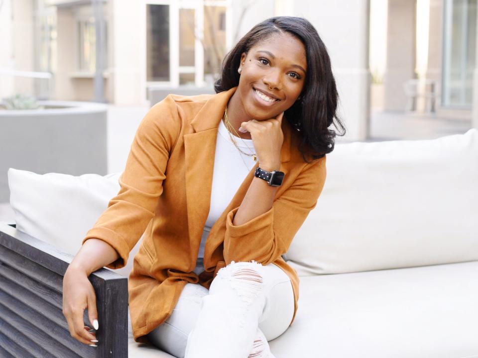 Camesha Whitmore sits on a white couch