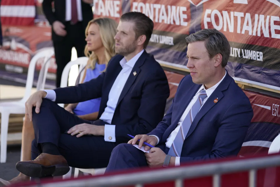 From left, White House press secretary Kayleigh McEnany, Eric Trump, son of President Donald Trump, and campaign manager for Donald Trump's 2020 presidential campaign Bill Stepien, listen as President Donald Trump speaks to a crowd of supporters during a campaign stop at Mariotti Building Product, Thursday, Aug. 20, 2020, in Old Forge, Pa. (AP Photo/Evan Vucci)