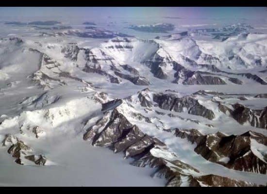 South of Beardmore Glacier, the Transantarctic Mountains are composed of high, blocky massifs topped by layers of flat-lying sedimentary rocks, as seen here in a portion of the Prince Olav Mountains. Shackleton Glacier flows to the right from the top center of the image.