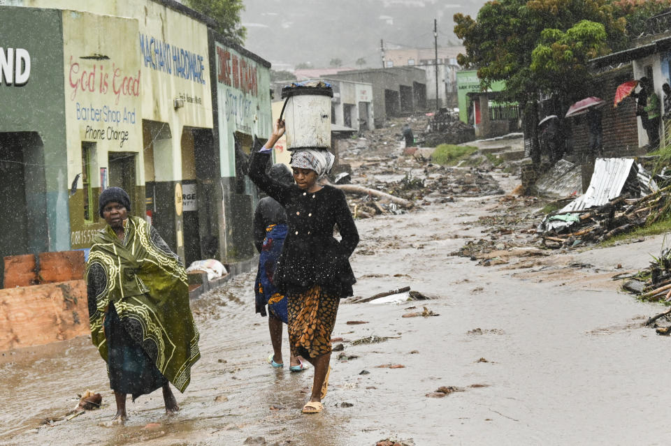 Women walk to a nearby displacement center in Blantyre, Malawi Tuesday March 14, 2023. The unrelenting Cyclone Freddy that is currently battering southern Africa has killed more than 50 people in Malawi and Mozambique since it struck the continent for a second time on Saturday night. (AP Photo/Thoko Chikondi)