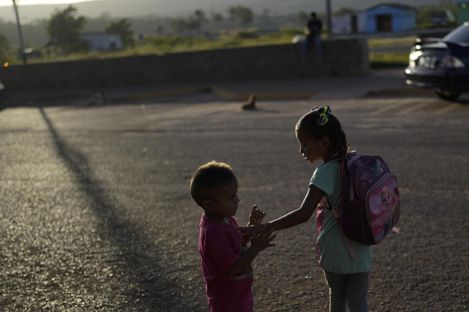 The children of Venezuelan migrants Miguel Gonzalez and Maryelis Rodriguez wait for a transportation that will take their family of six to the border with Brazil, in Santa Elena, Venezuela, Wednesday, April 5, 2023. A Venezuelan exodus to Brazil has set post-pandemic records. (AP Photo/Matias Delacroix)