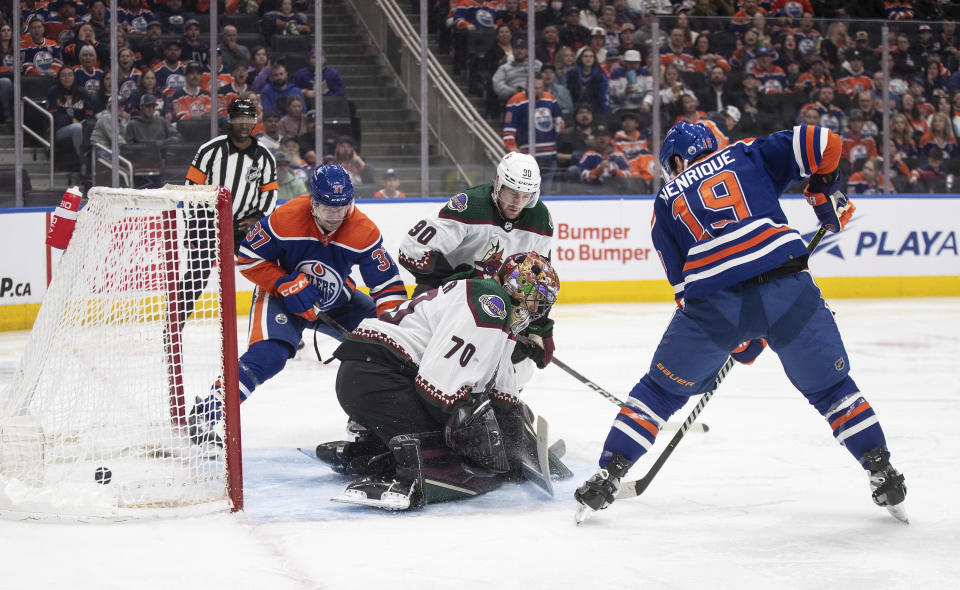 Arizona Coyotes goalie Karel Vejmelka (70) is scored on by Edmonton Oilers' Adam Henrique (19) during the second period of an NHL hockey game Friday, April 12, 2024, in Edmonton, Alberta. (Jason Franson/The Canadian Press via AP)