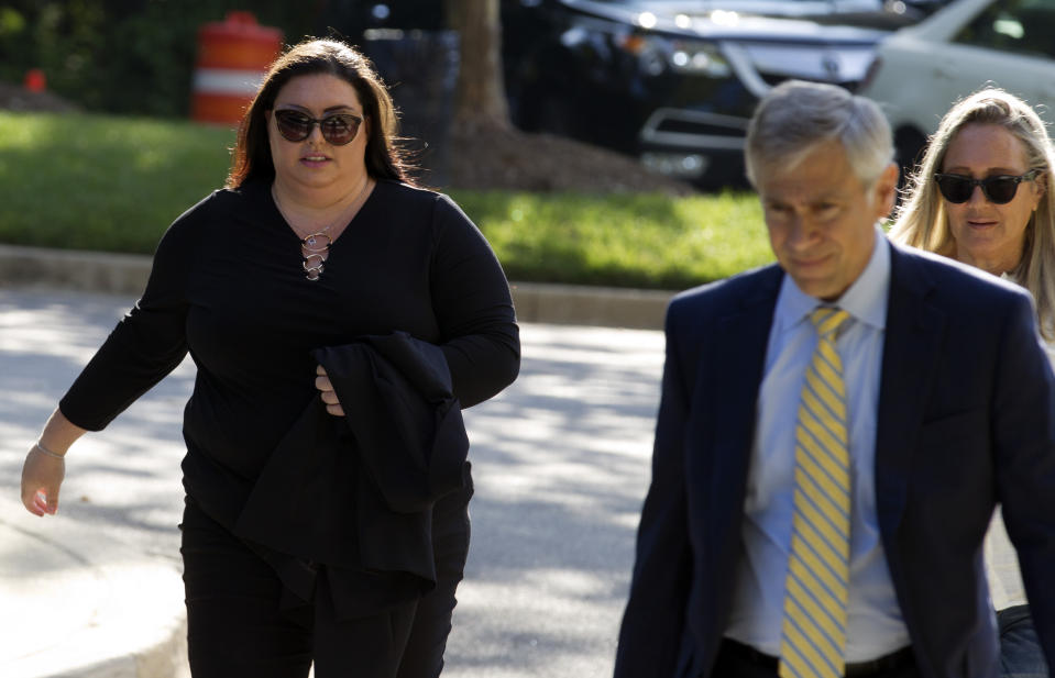 Lee Elbaz, left, accompanied by her attorney Barry Pollack arrives at federal court for jury selection in her trial in Greenbelt, Md., Tuesday July 16, 2019. Elbaz was CEO of an Israel-based company called Yukom Communications. She is accused of engaging in a scheme to dupe investors through the sale and marketing of financial instruments known as "binary options." (AP Photo/Jose Luis Magana)