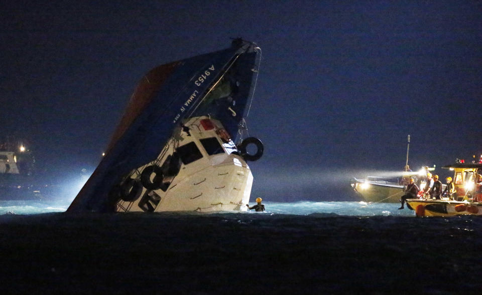 Rescuers check on a half submerged boat after it collided Monday night near Lamma Island, off the southwestern coast of Hong Kong Island Tuesday, Oct. 2, 2012. Authorities in Hong Kong have rescued 101 people after a ferry collided with a tugboat and sank. A local broadcaster says eight people died. (AP Photo/Kin Cheung)