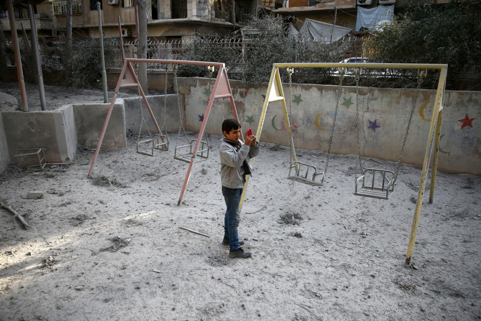 <p>A boy is seen taking pictures after an air raid in the besieged town of Douma in eastern Ghouta in Damascus, Syria, Feb. 6, 2018. (Photo: Bassam Khabieh/Reuters) </p>