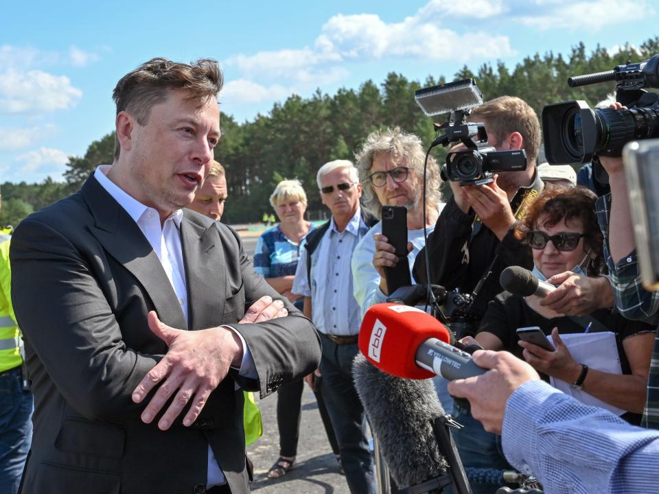 elon musk journalists crowd no mask tesla construction