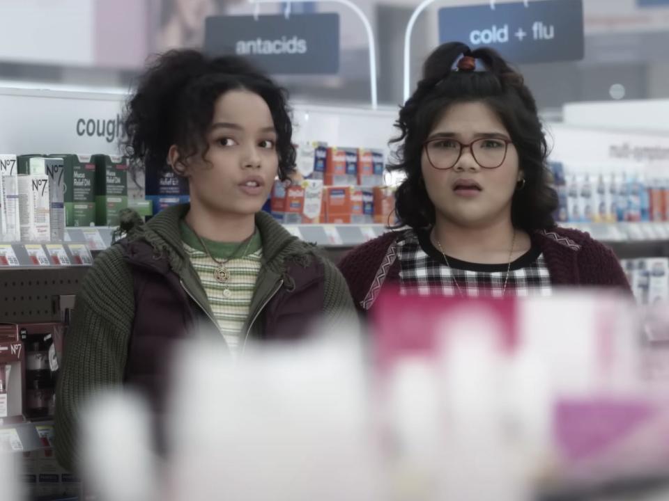 two girls standing, looking nervous, in grocery store aisle in hocus pocus 2