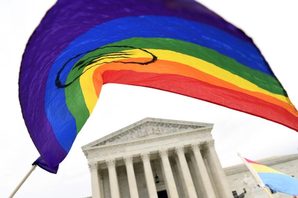 In this Oct. 8, 2019 file photo, protesters gather outside the Supreme Court in Washington where the Supreme Court is hearing arguments in the first case of LGBT rights since the retirement of Supreme Court Justice Anthony Kennedy. (AP Photo/Susan Walsh, File)