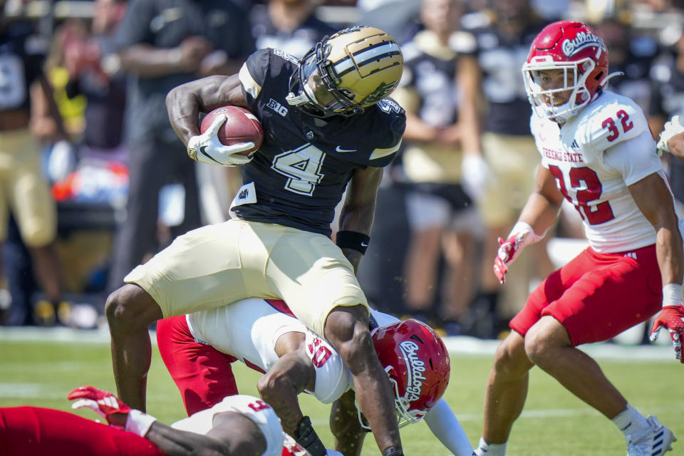 Purdue wide receiver Deion Burks (4) evades a tackle by Fresno State defensive back Kosi Agina (10) in route to a touchdown during the first half of an NCAA college football game in West Lafayette, Ind., Saturday, Sept. 2, 2023. (AP Photo/AJ Mast)