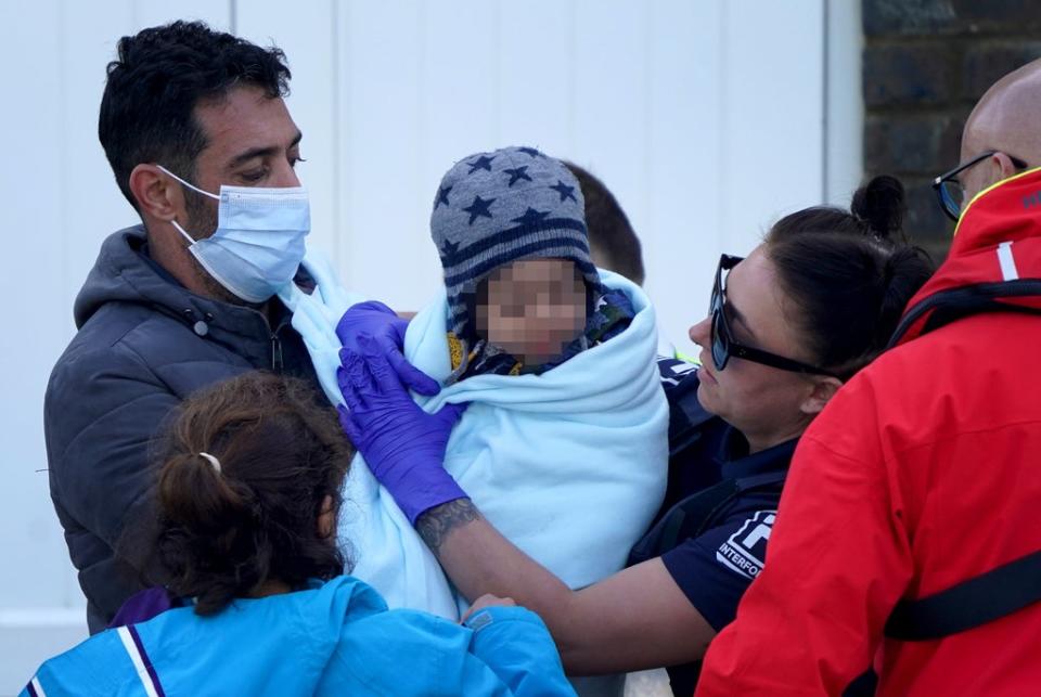 A young child wrapped in a blanket is among a group of people thought to be migrants brought in to Dover, Kent  (PA Wire)