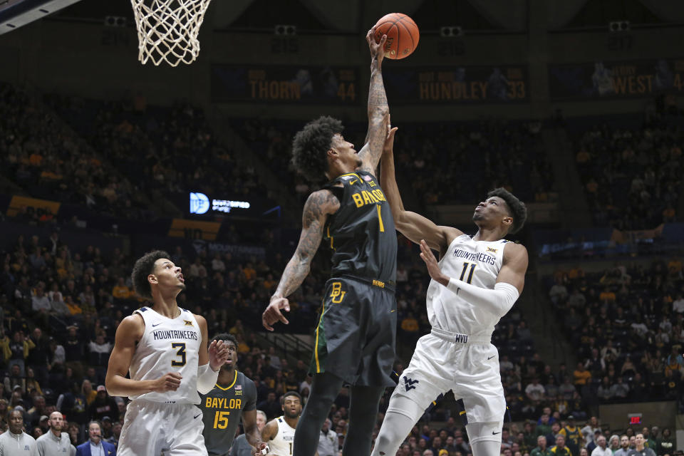 West Virginia forward Mohamed Wague (11) is defended by Baylor forward Jalen Bridges (11) during the second half of an NCAA college basketball game in Morgantown, W.Va., Wednesday, Jan. 11, 2023. (AP Photo/Kathleen Batten)