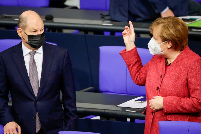 FILE PHOTO: German Chancellor Angela Merkel speaks with German Finance Minister Olaf Scholz in Berlin