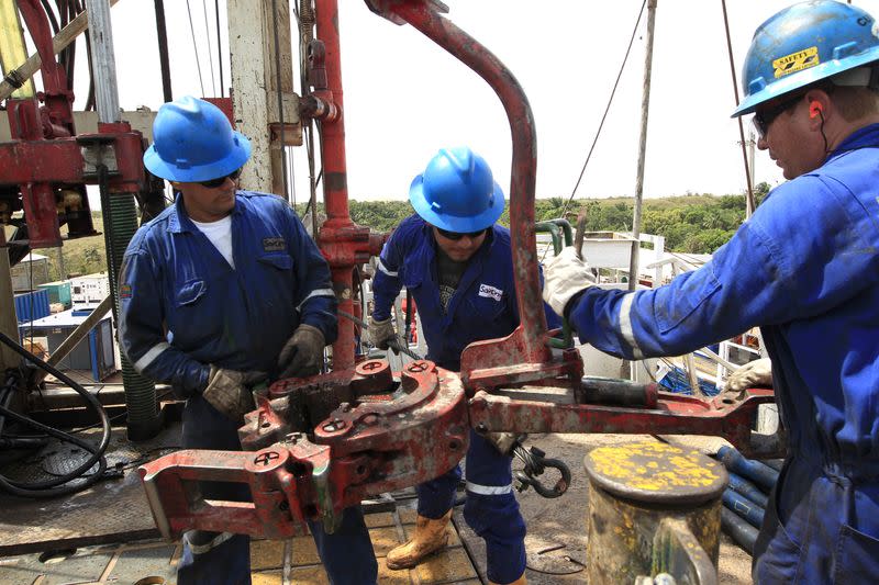 Foto de archivo. Empleados trabajan junto a tuberías de excavación de petróleo en el Campo Rubiales en Puerto Gaitán, departamento del Meta