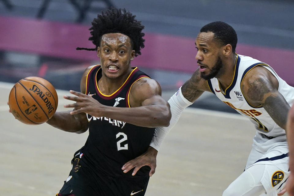 Cleveland Cavaliers' Collin Sexton, left, drives past Denver Nuggets' Monte Morris in the first half of an NBA basketball game, Friday, Feb. 19, 2021, in Cleveland. (AP Photo/Tony Dejak)