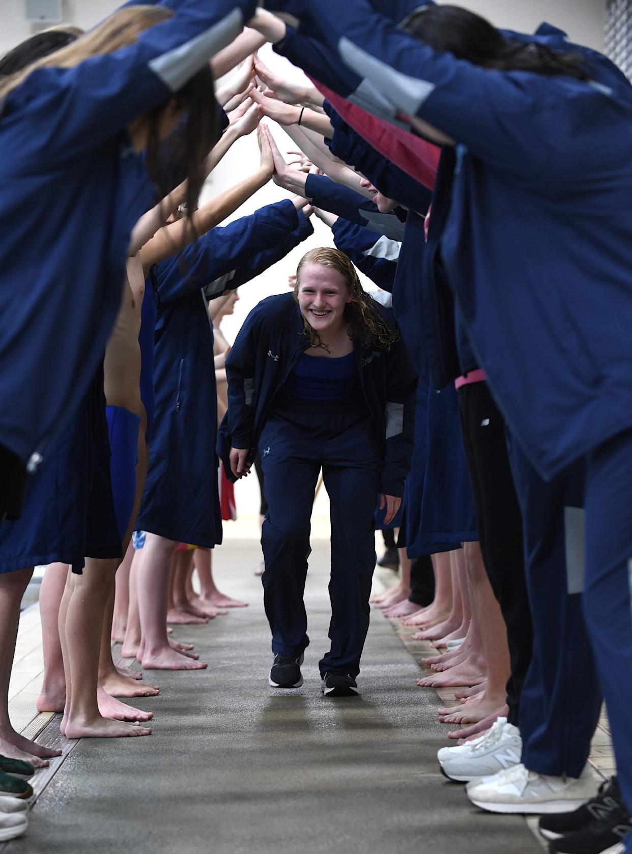 Bartlesville High School senior Tristin Weaver runs through a tunnel made by her teammates during Senior Night at the Phillips 66 Aquatic Center in Bartlesville on Jan. 23, 2024. Other seniors were Griffin Craig, Emma Howze, Cody Lay, Regan Patzkowski and Lily Talbot.